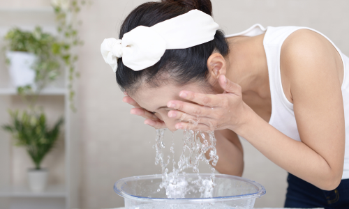 水で洗顔をする女性